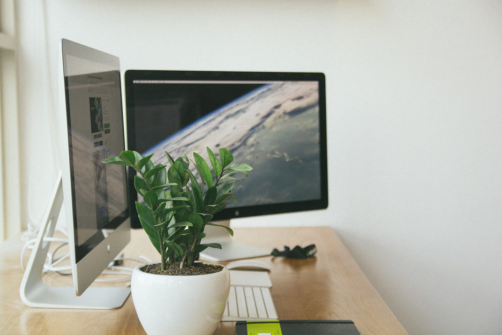 A clean flat-lay of a laptop, phone, and headphones with four labeled sticky notes reading distribution, analytics, projects, and CRM.