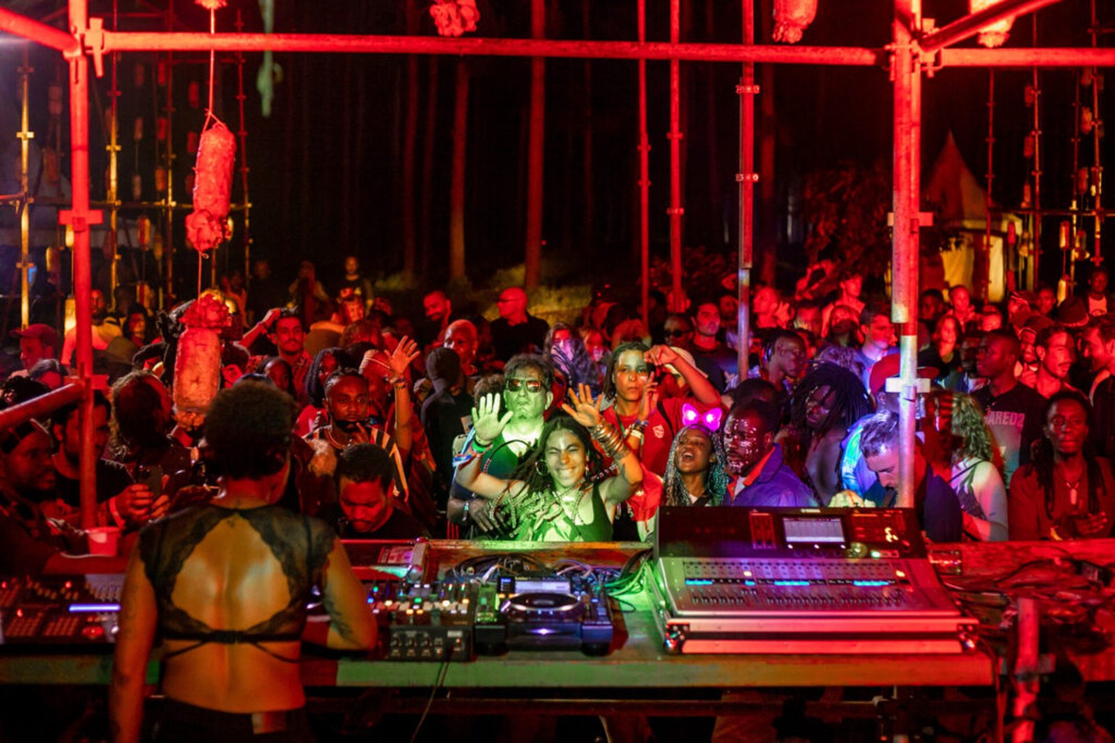 DJ performing to a dense nighttime crowd in red light at Nyege Nyege Festival