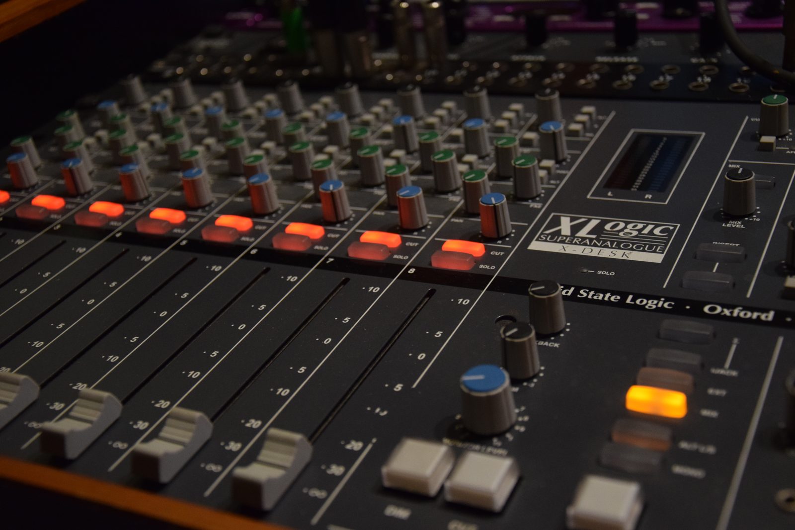 Recording studio mixing console with channel faders lit up