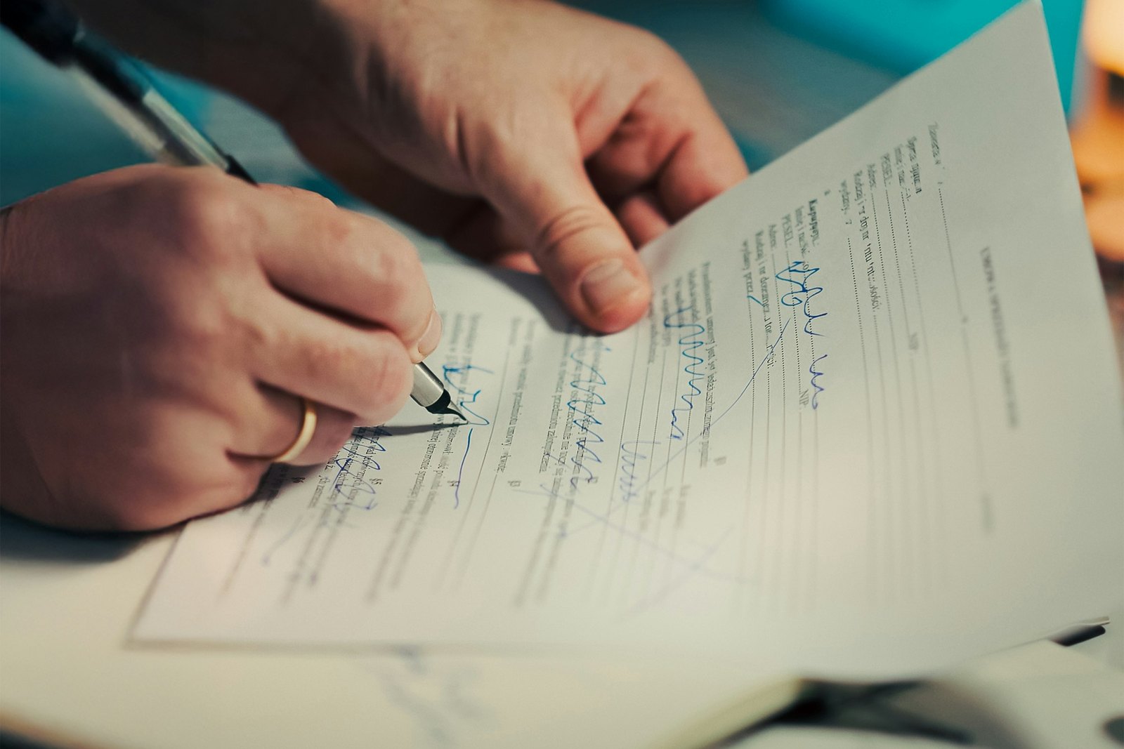 A man signing a document with a pen