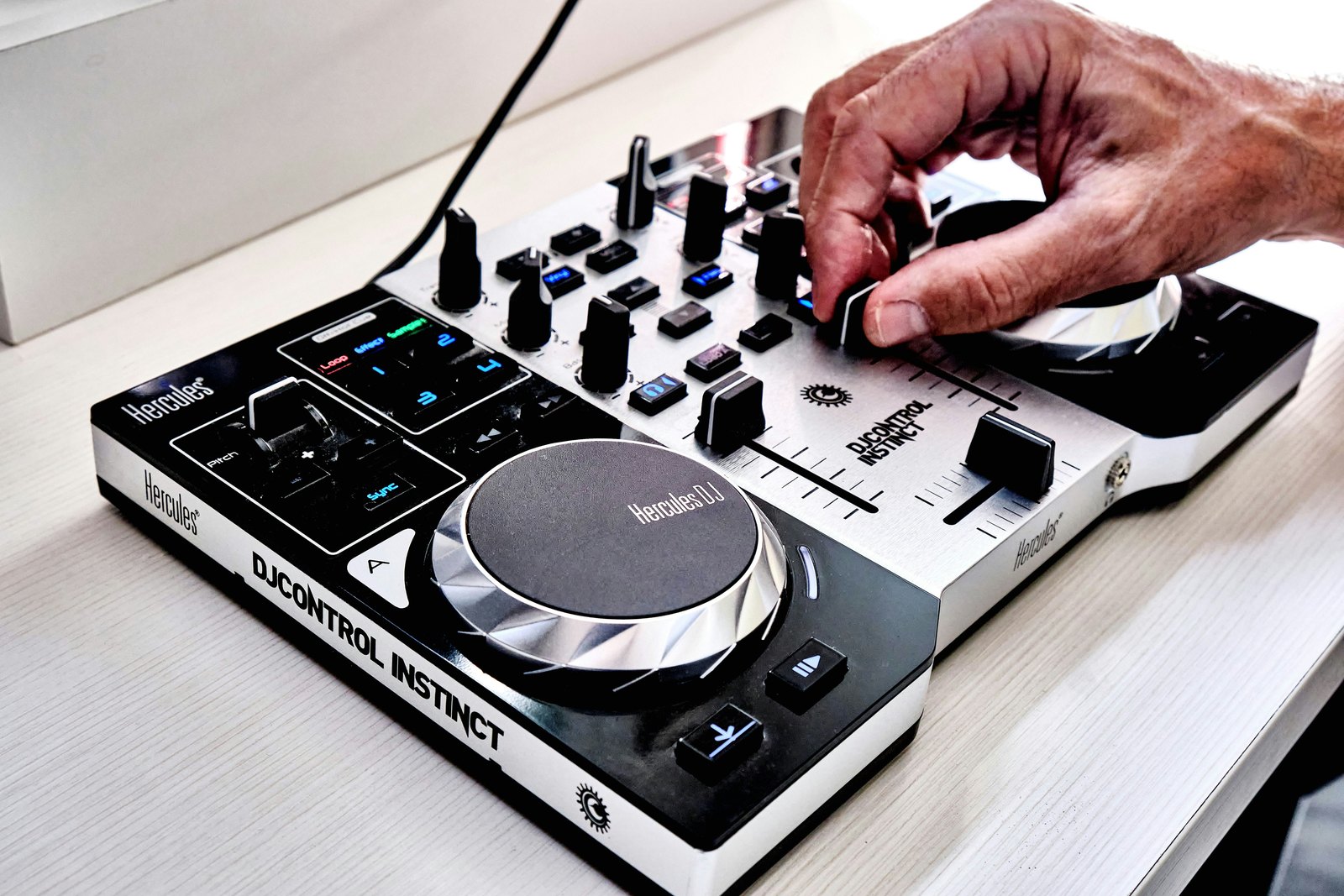 A man using a DJ controller on a table