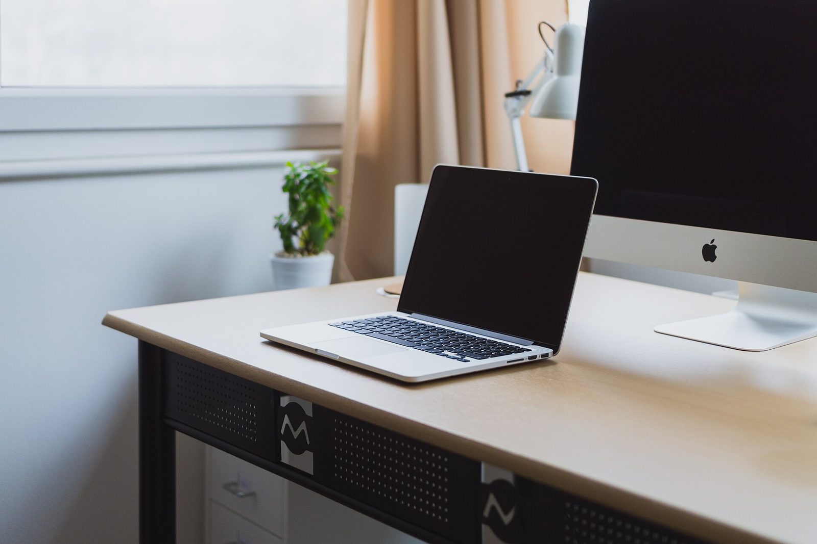 A clean desk with a laptop showing a single organized dashboard of tasks, money, and contacts, calm and uncluttered.