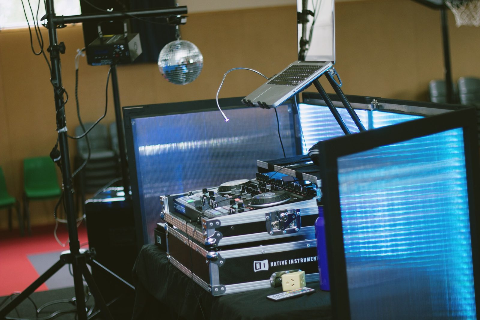 DJ booth with controller, laptop and mirror ball at a venue