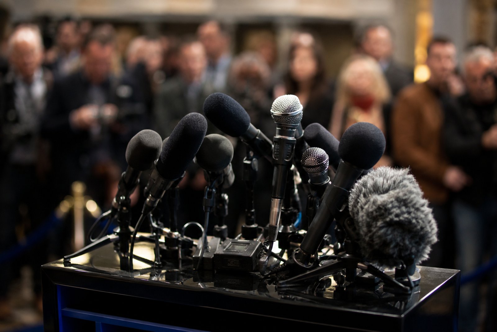A publicist at a desk surrounded by music magazines and a laptop open to a list of press contacts.
